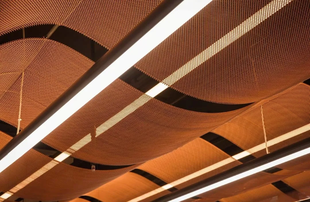 Metal coil drapery used as a soft ceiling feature