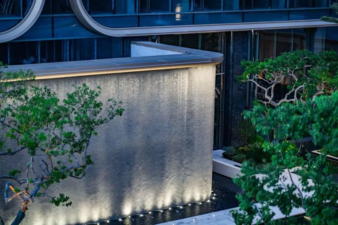 Metal coil drapery used as a vertical water-feature wall surface
