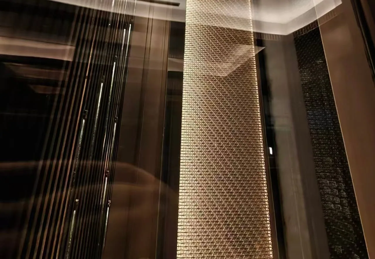 Protected glass build-up with decorative metal mesh in an elevator cab interior