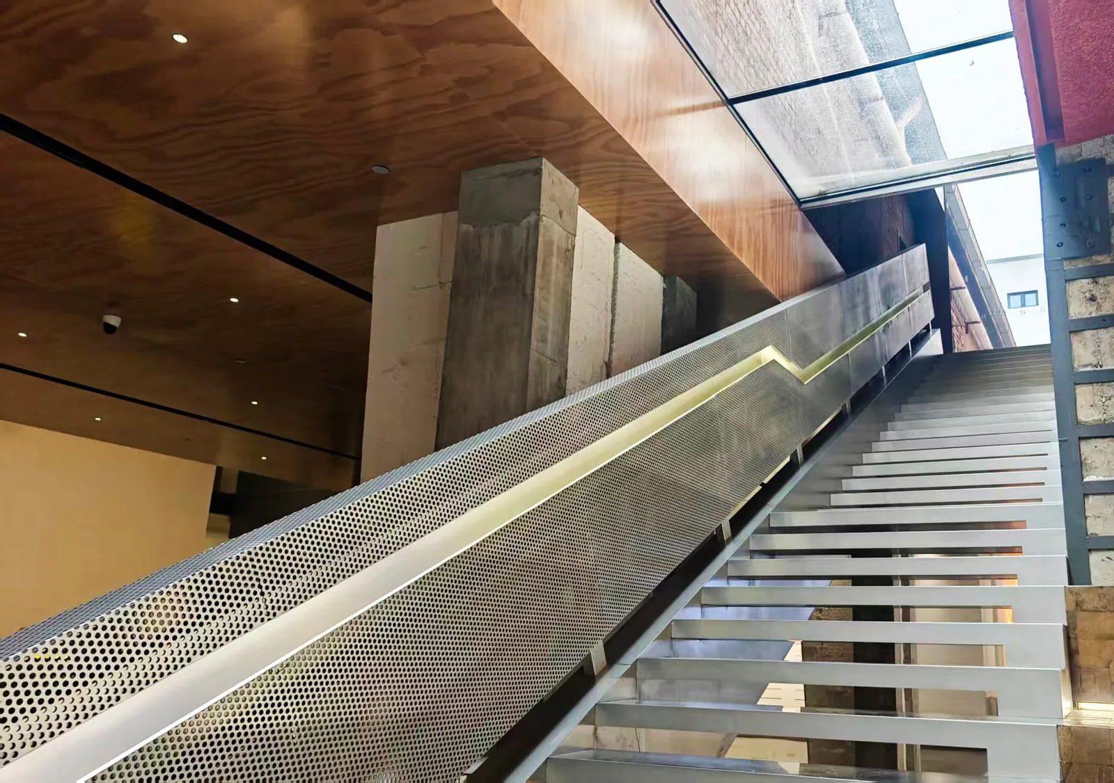 Perforated sheet metal stair protection panel with integrated handrail lighting